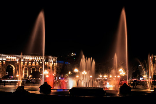 Musical fountain with colorful illumination at night with reflec