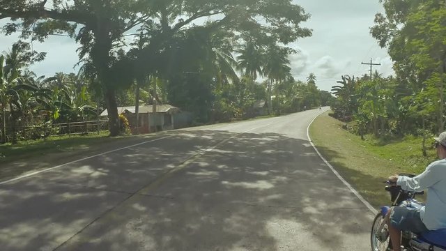 Village Road. Motion on motorbike. Philippines. Bohol island. Driving forward