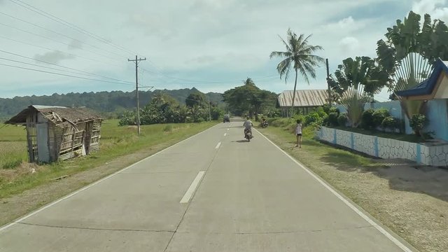 Village Road. Motion on motorbike. Philippines. Bohol island. Driving forward..