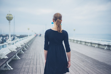 Obraz premium Young woman walking on the pier
