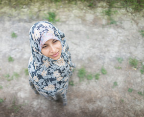 Beautiful happy Muslim woman in green field