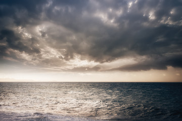 Amazing evening landscape. Stormy ocean with sunset cloudy sky