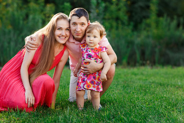 Fototapeta premium Happy family with small daughter on lawn