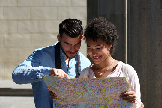 Junges, attraktives Paar schaut in Stadtplan und sucht den Weg