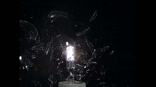 Exploding light bulb  against black background, slow motion