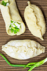 Uncooked pies. Filling - green onions and eggs. Sprig of green o