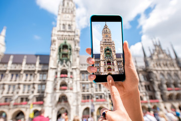 Photographing with smart phone the clock tower of the town hall in Munich city, Germany