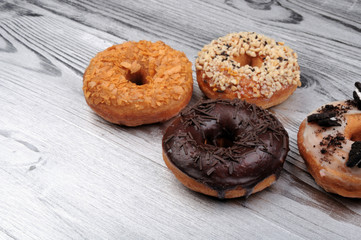 Fresh tasty donuts in soft colorful glaze on a silver wooden background