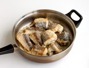 Pieces of fried fish in a frying pan