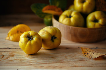 An autumn still life with quinces on wooden table