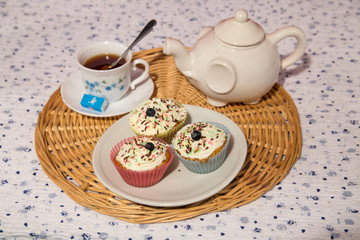 Afternoon tea with cakes on the table top view. Muffins on white table with black tea. The Time of Tea Break.