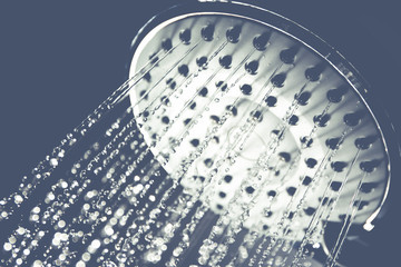 Image of a modern shower head splashing water close up background. (Processed in vintage colour tone)
