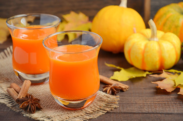 Healthy pumpkin juice in glasses on autumn background, selective focus
