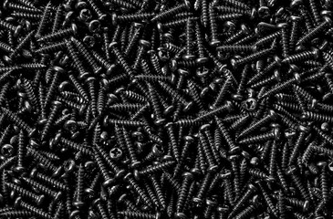 Background pile of shiny black screws - obrazy, fototapety, plakaty
