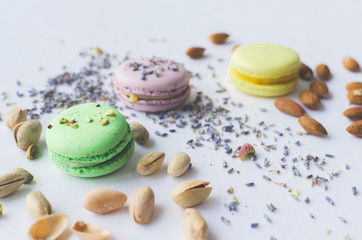 yellow, green and purple macaron cakes or macaroon on white background, sweet and colorful dessert, above, almond cookies, pastel color, vintage card, lavender, pistachios and almond on the background