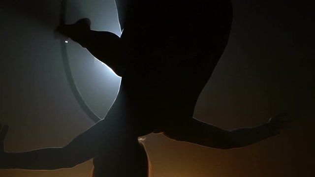 Aerial acrobat woman on circus stage. Silhouette