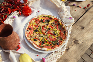 Vegetable pizza served on white plate on wooden table 

