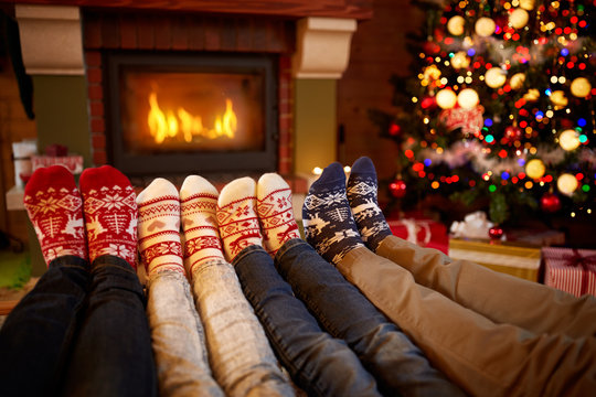 Feet In Wool Socks Near Fireplace In Christmas Time.