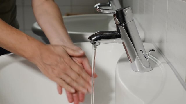 female washing hands in a sink