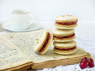Fototapeta na wymiar cup of espresso coffee and French macaroons dessert stuffed with cornel on light wooden background