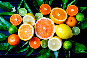 Assorted fresh citrus fruits with leaves - obrazy, fototapety, plakaty