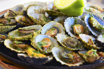 Tasty seafood grilled limpets served with lemon.Lapas grelhadas.Madeira's traditional dish and a...