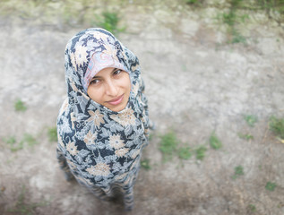 Beautiful happy Muslim woman in green field