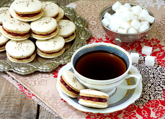 cup of espresso coffee and French macaroons dessert on wooden background