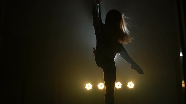 Aerial acrobat woman on circus stage. Silhouette