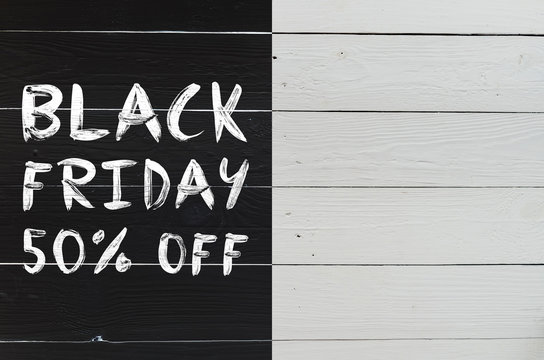 Black friday 50% brush hand lettering on white painted rustic barn wooden planks. Sale banner template. Space for copy, text, lettering.