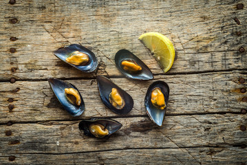 Delicious cooked mussels on a wooden background