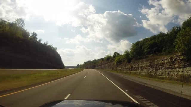 POV Car driving on an empty two lane highway in Tennessee on a cloudy day with trees.