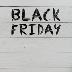 Black friday brush hand lettering on white painted rustic barn wooden planks. Sale banner template. Space for copy, text, lettering.