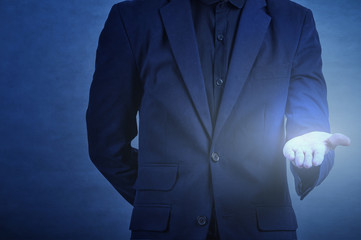 man in formal wear touching empty virtual glass upturned palms  over dark blue background,business concept