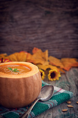 Thanksgiving Pumpkin soup on rustic background with copy space 