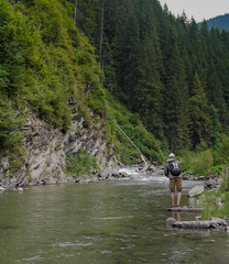 Fototapeta na wymiar Fishing on the mountain river. Fisherman fishing in the mountains