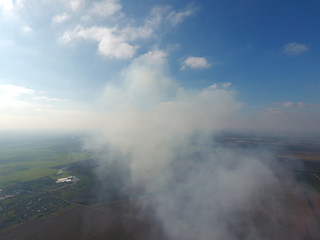 The smoke over the village. Clubs of smoke over the village houses and fields. Aerophotographing areas