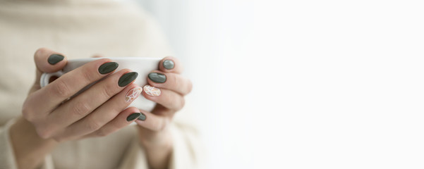 well-groomed hands with a cup of tea