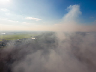 The smoke over the village. Clubs of smoke over the village houses and fields. Aerophotographing areas