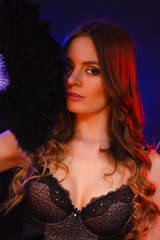 Woman holding carnival feather fan in hand.