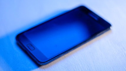 smartphone on a white background in a blue glow