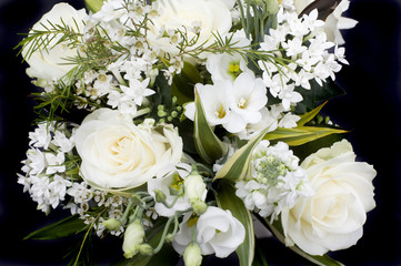 an arrangement of white flowers on a black background