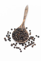 Black pepper in spoon wooden bowl isolated on white background