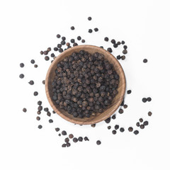 Black pepper in wooden bowl isolated on white background