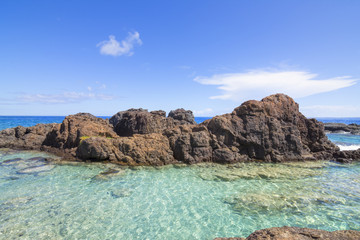 Fototapeta na wymiar Turquoise pool on rocky tropical sea shore