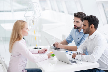 Young coworkers having brainstorming session in modern office
