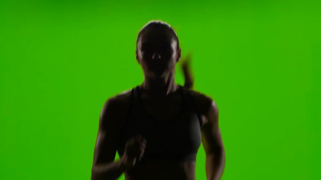 Athletic woman is jogging. Front view. Green screen