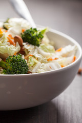 Asian Napa cabbage salad with organic broccoli, almonds, chicken, and a rice vinaigrette side view macro shot
