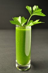 Green smoothie with parsley and kale on black background, front view
