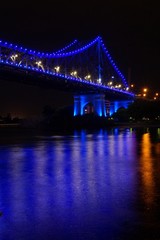 Fototapeta na wymiar blue bridge lights at night over a river